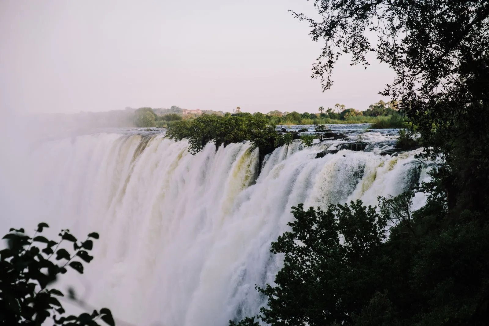 The falls in soft evening light, framed by dark trees