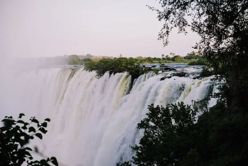 The falls in soft evening light, framed by dark trees