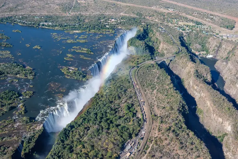 Aerial view of the falls, the gorges and Victoria Falls Bridge, a rainbow in the spray