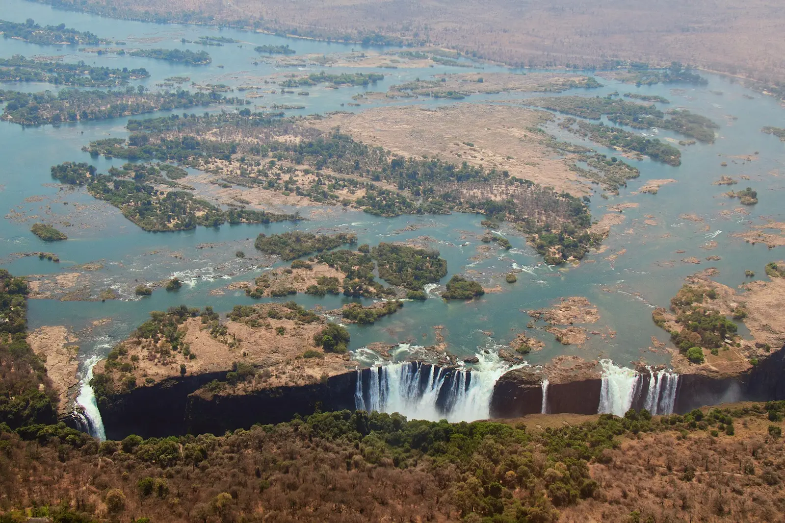Victoria Falls spans the Zambezi River, with braided channels and islands upstream.