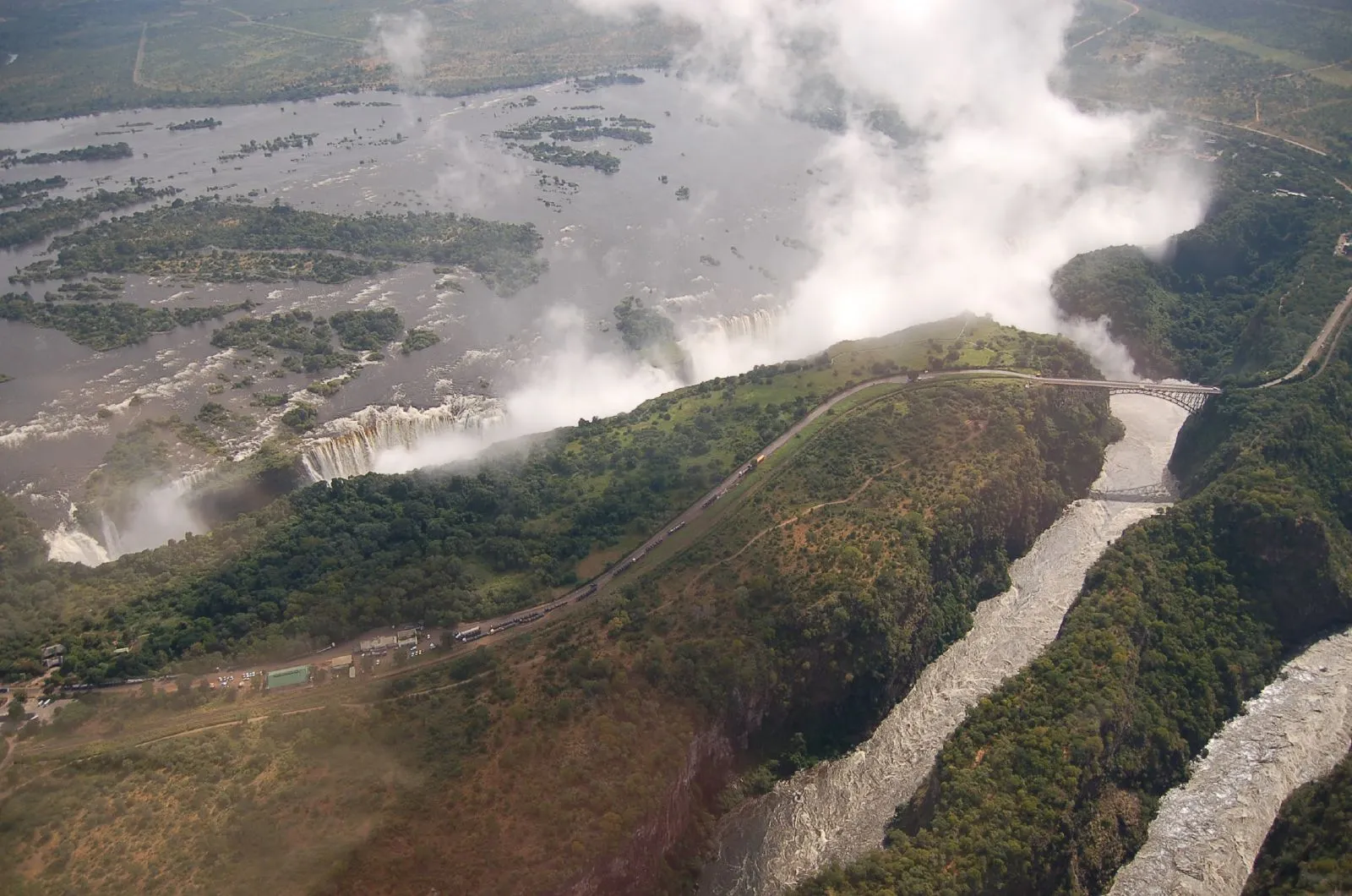 Aerial view of the falls in spray, the zigzag gorges and Victoria Falls Bridge
